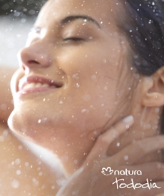 Mujer disfrutando del frescor de las intensas gotas de agua que caen sobre su cuerpo