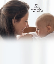 Mama con su bebe en la cuna, bebe tocando la boca de la mama sonriendo
