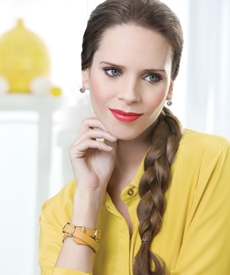 Mujer maquillada en ojos y labios con productos Natura Aquarela, sonriendo