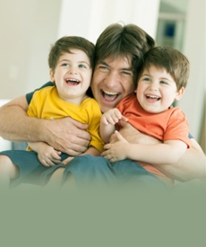 Padre con sus dos hijos abrazados y sonriendo