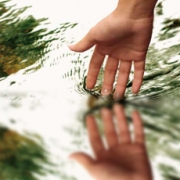 Mano de una mujer tocando muy suavemente agua.