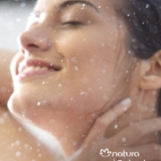 Mujer disfrutando del frescor de las intensas gotas de agua que caen sobre su cuerpo