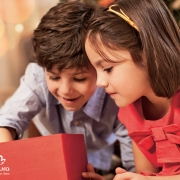 Dos niños observando un regalo, sonrien